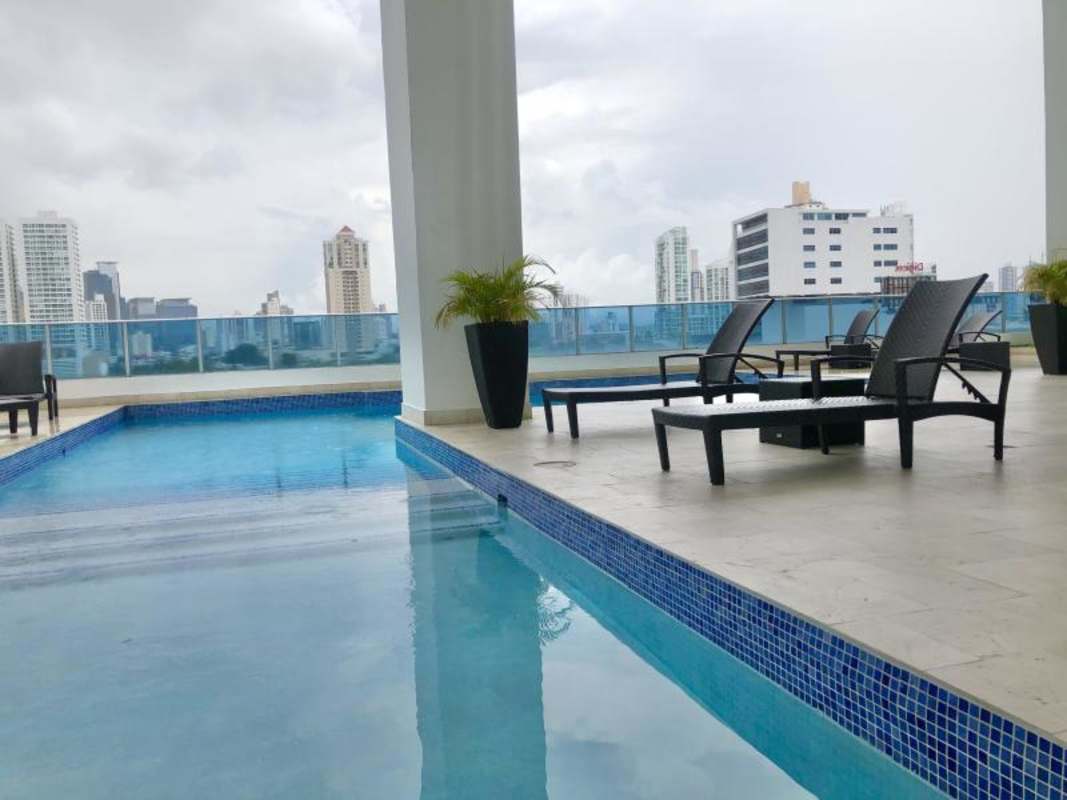 Covered pool lounge with glass wall city views at PH Joy Tower Panama