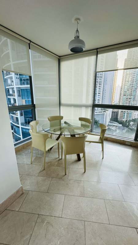 Kitchen with stainless appliances, marble counters, dark wood cabinetry at Grand Tower Punta Pacifica