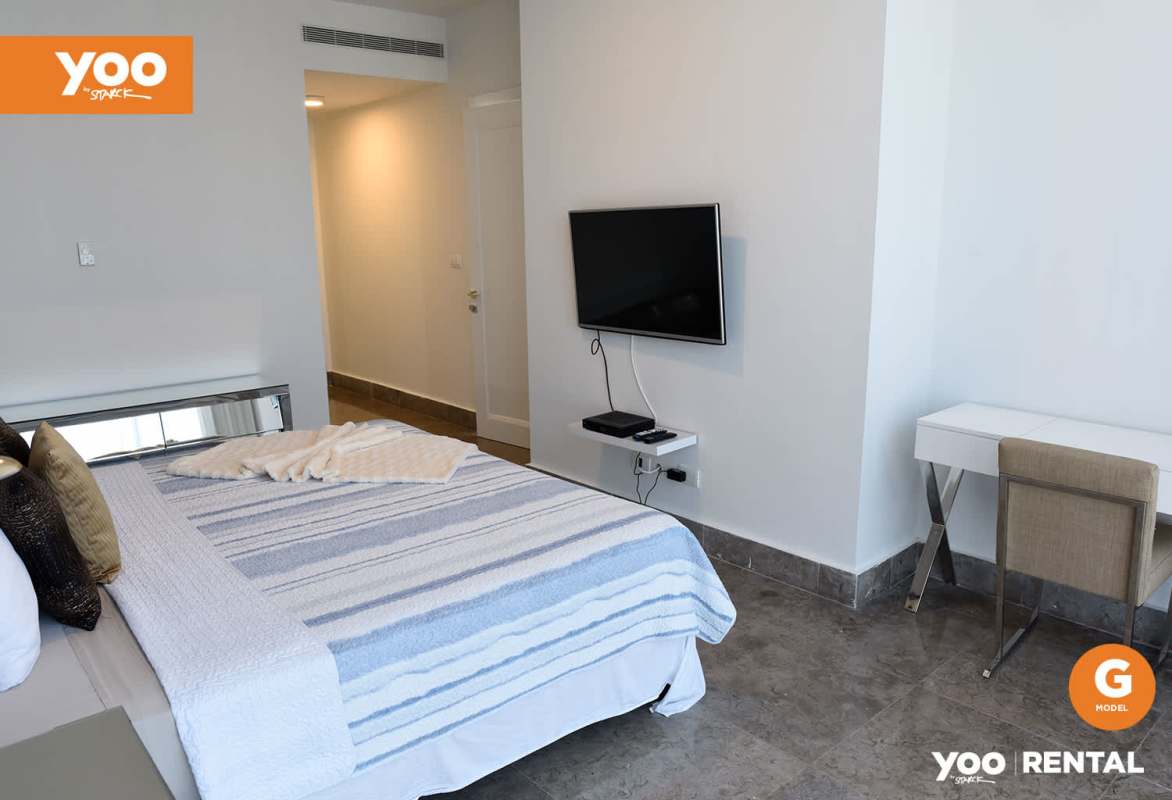 Modern bedroom with mounted TV and workspace PH Yoo Panama