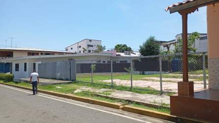 Vacant lot on paved street surrounded by shops and homes in Las Tablas Panama