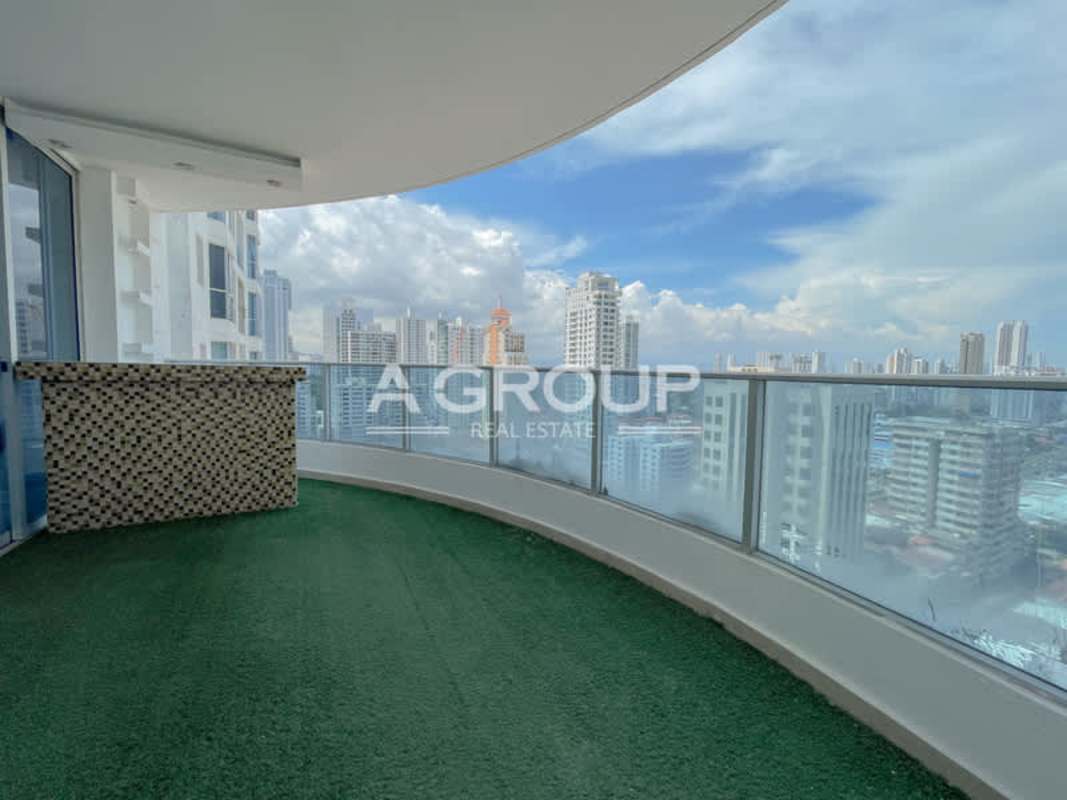 Curved balcony with artificial grass, mosaic-tiled bar, and skyline view PH Joy Tower Panama