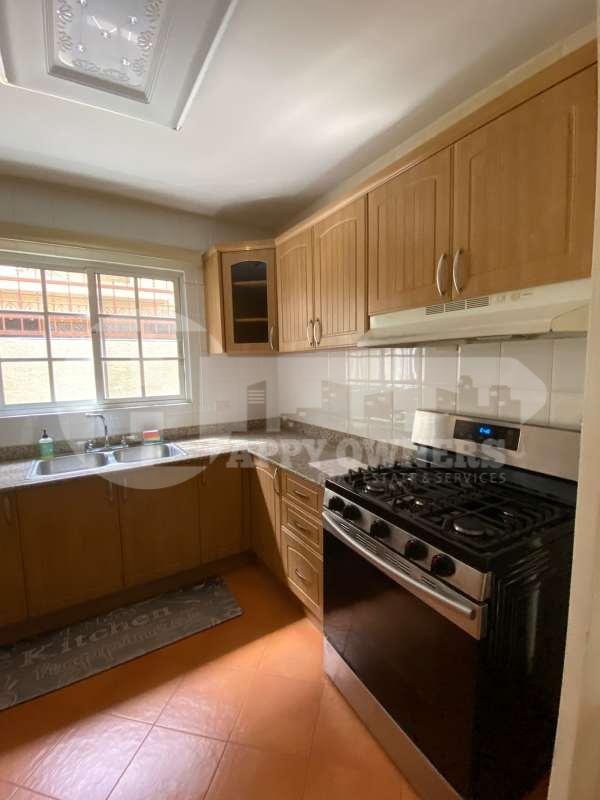 Kitchen with wood cabinetry, granite countertops and large window PH Albrook Gardens Clayton Panama