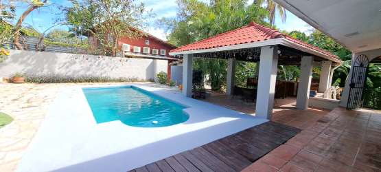 Traditional semi-open kitchen with tile countertops and gas stove at Panama beach house for sale