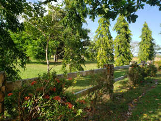 Rustic fenced large lot with white house in countryside setting close to beaches