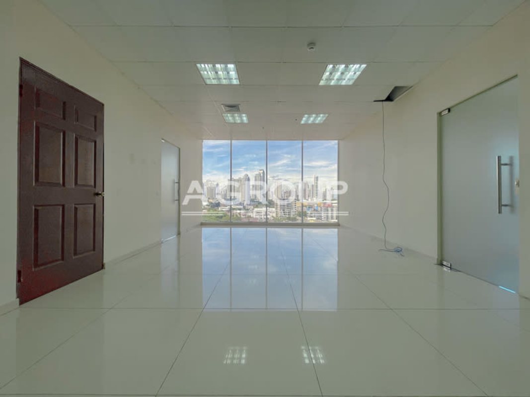 Office space with large windows, executive furniture, conference table, and panoramic city skyline view in PH Office One Obarrio Panama