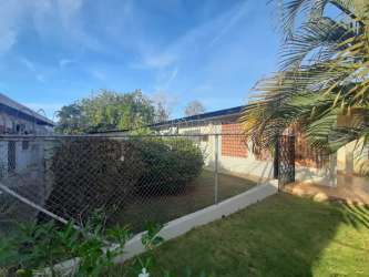 Front garden and porch area with security fence of single-story house in Chitré Los Santos