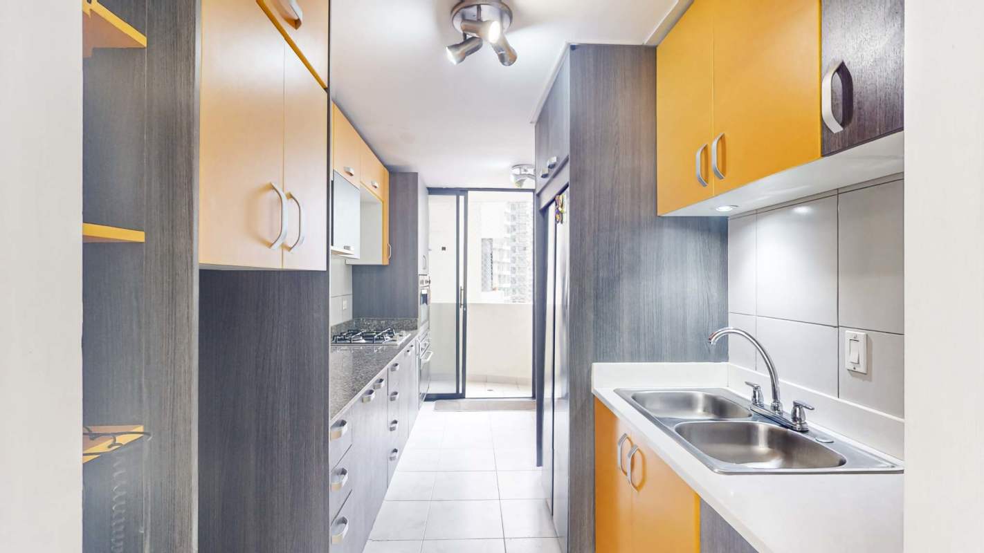 Enclosed kitchen with grey cabinetry, granite countertops and built-in oven in PH Perla del Pacífico