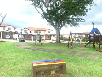 Security booth gated entrance with palm trees at Costa Verde Gran Reserva Montelimar Panama