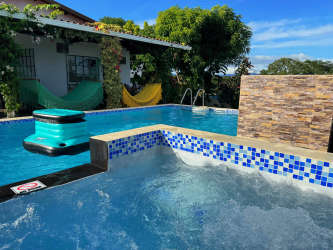 Bright living room with large couch, Smart TV and ceiling fan in Las Uvas rental home