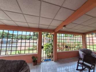 Enclosed sunroom with tiled floor large windows overlooking garden in La Chorrera home for sale