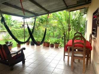 Covered porch with hammock and garden in Puerto Caimito