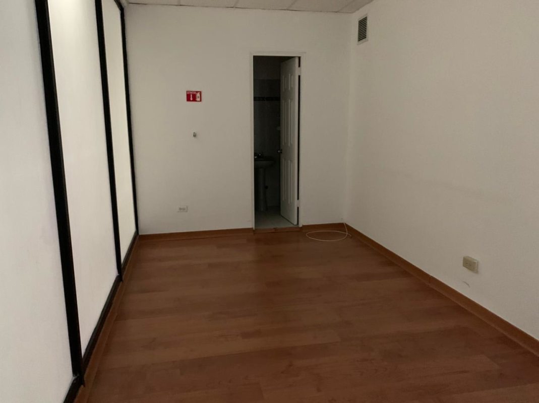 Partitioned interior with wood floor, white walls and restroom door at The Century Tower Panama