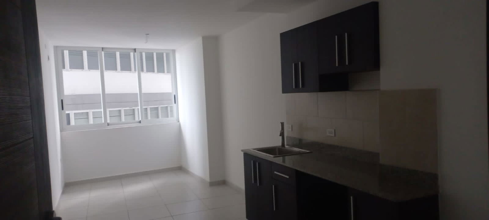 Kitchen area with granite countertop, large window with views, and cabinetry in Bay View Tower Panama