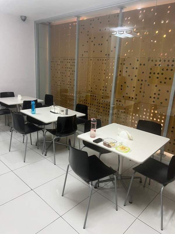 Modern dining or break area white tiles, black chairs commercial Obarrio Panama