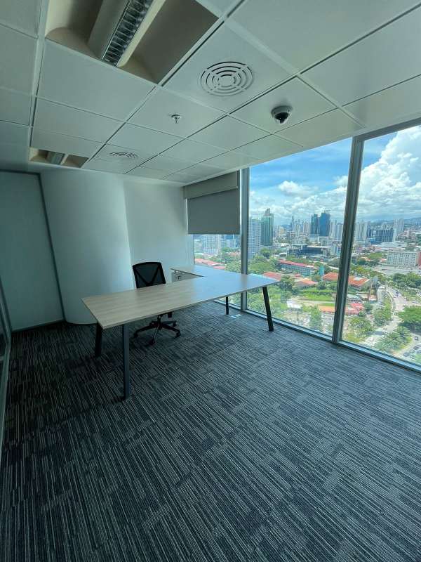 Modern open-plan workstations with glass walls and carpet flooring inside Oceania Tower Punta Pacifica Panama