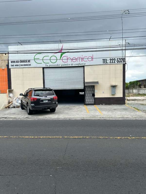 Exterior view commercial warehouse rolling metal door parking lot Eco Chemical signage Panama City