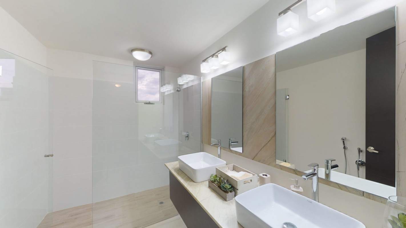 Modern bathroom with double vessel sinks and walk-in shower in Villasur Panama