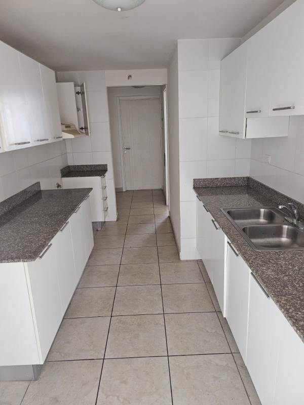 Modern galley style kitchen with granite countertops white cabinets in Condado Country Club Panama