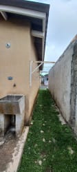 Small grassy backyard enclosed by wall with laundry area in foreclosure house Panama