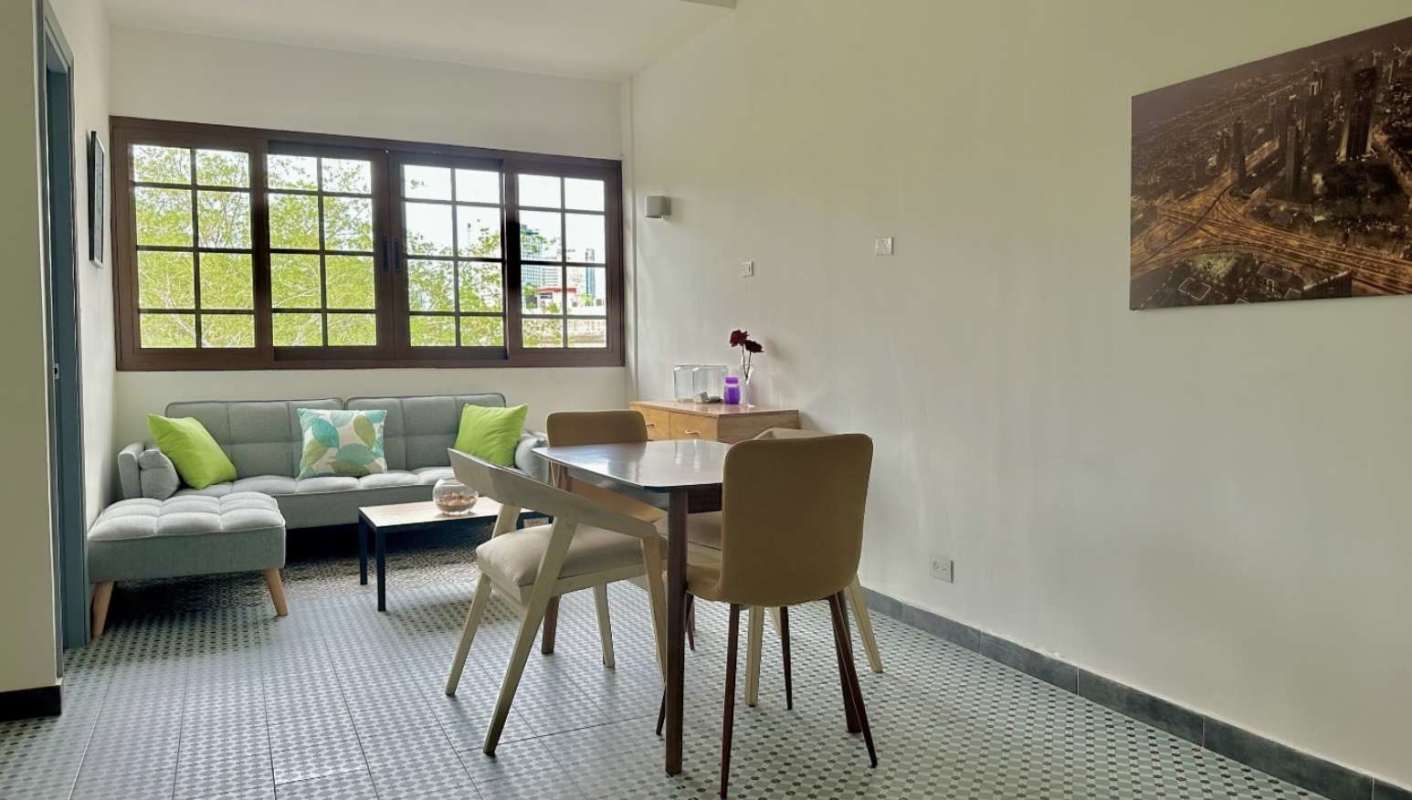 Minimalist living dining with gray sectional sofa, large window, artwork Casco Viejo Panama