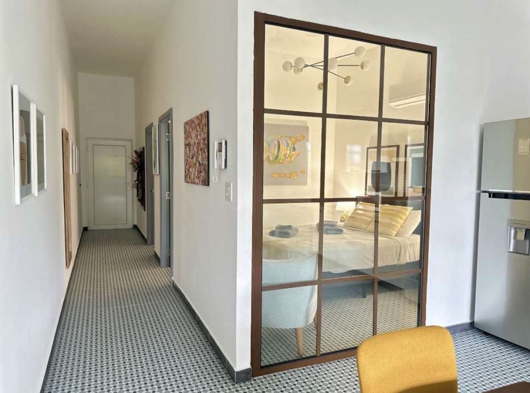 Bedroom with gray bed, striped pillows, wall art, AC unit Casco Viejo Panama