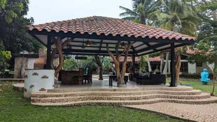 Thatched roof pavilion with outdoor dining next to pool in Coronado Panama luxury house