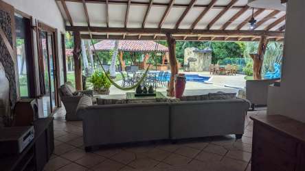 Spacious living room with hammock, rustic beams, pool view in Coronado Golf luxury villa Panama