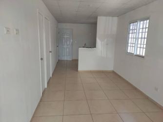 Minimalist kitchen with small sink cabinet tiled floors barred window La Chorrera Panama
