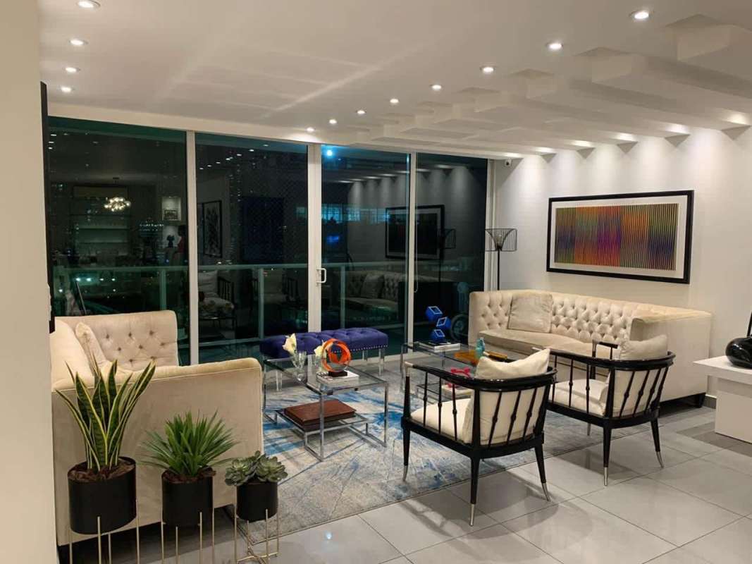 Spacious living room with cream sofas, glass coffee table and city view in Punta Pacifica Panama