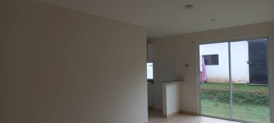 Empty living and dining space with neutral walls and tile floor in bank sale house Las Arboledas La Chorrera Panama