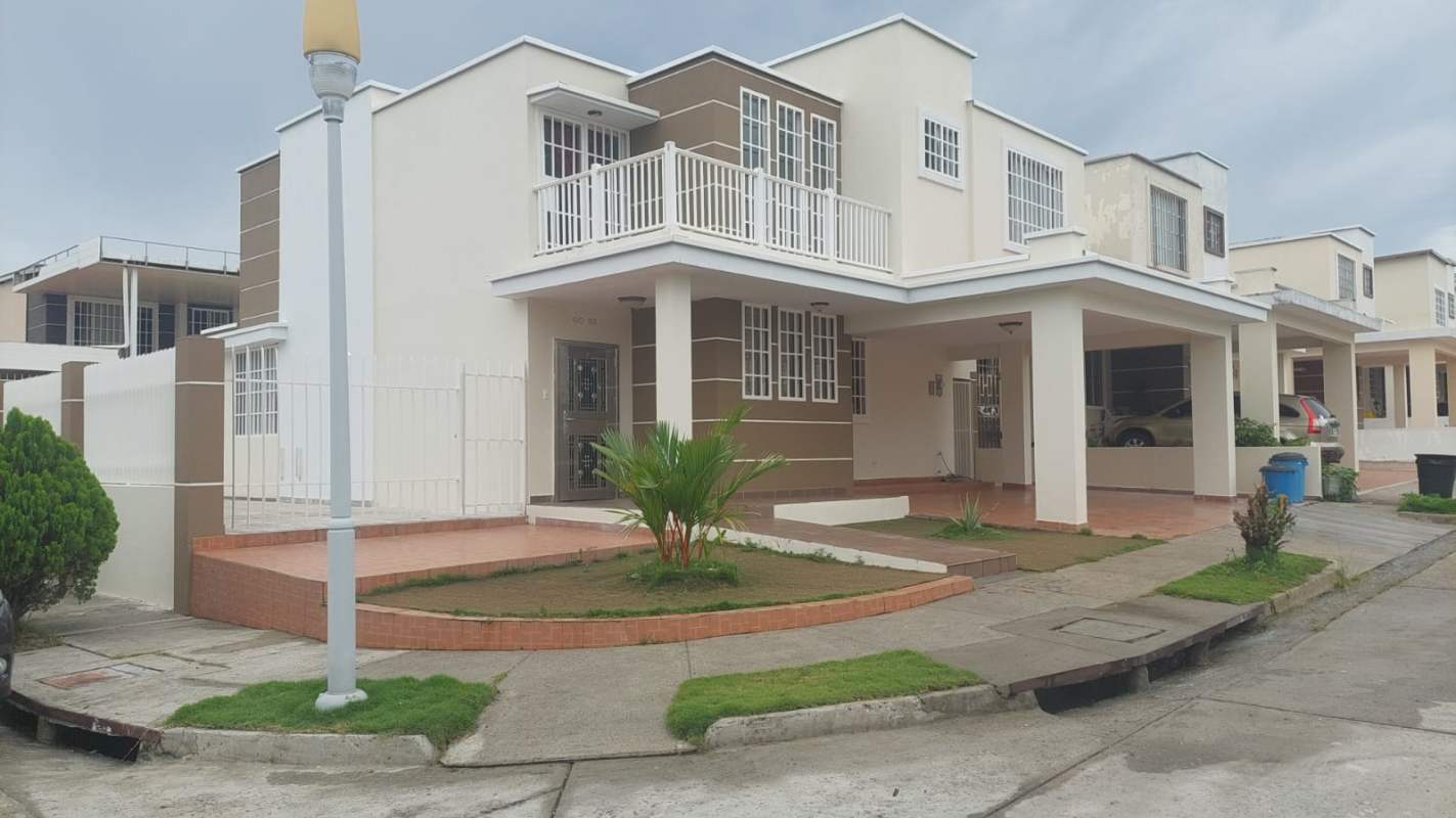 Front of modern two-story home with balcony and covered carport in PH Brisas Point Brisas del Golf
