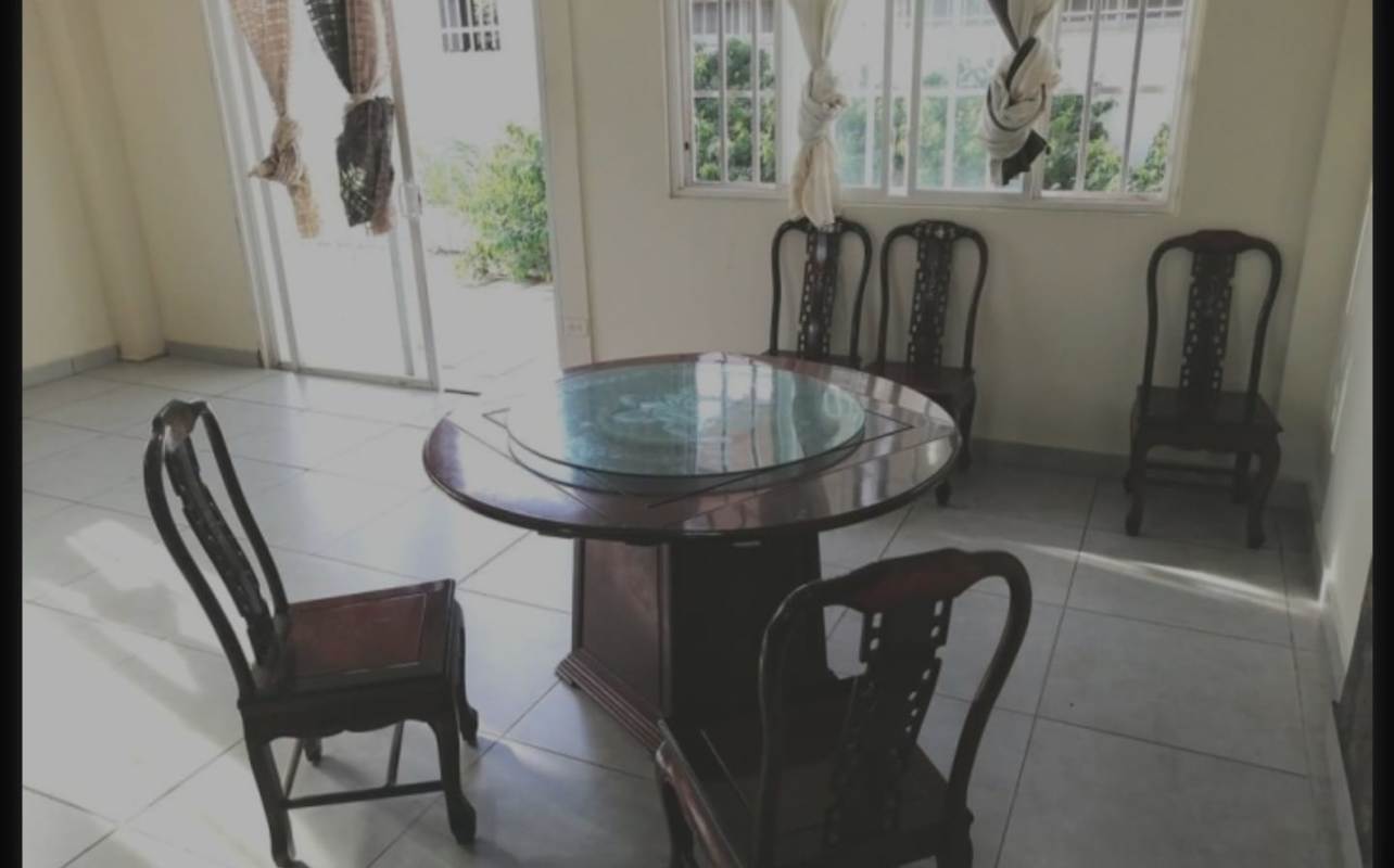 Traditional dining room with wood table, six chairs and sliding doors to patio in PH Brisas Point