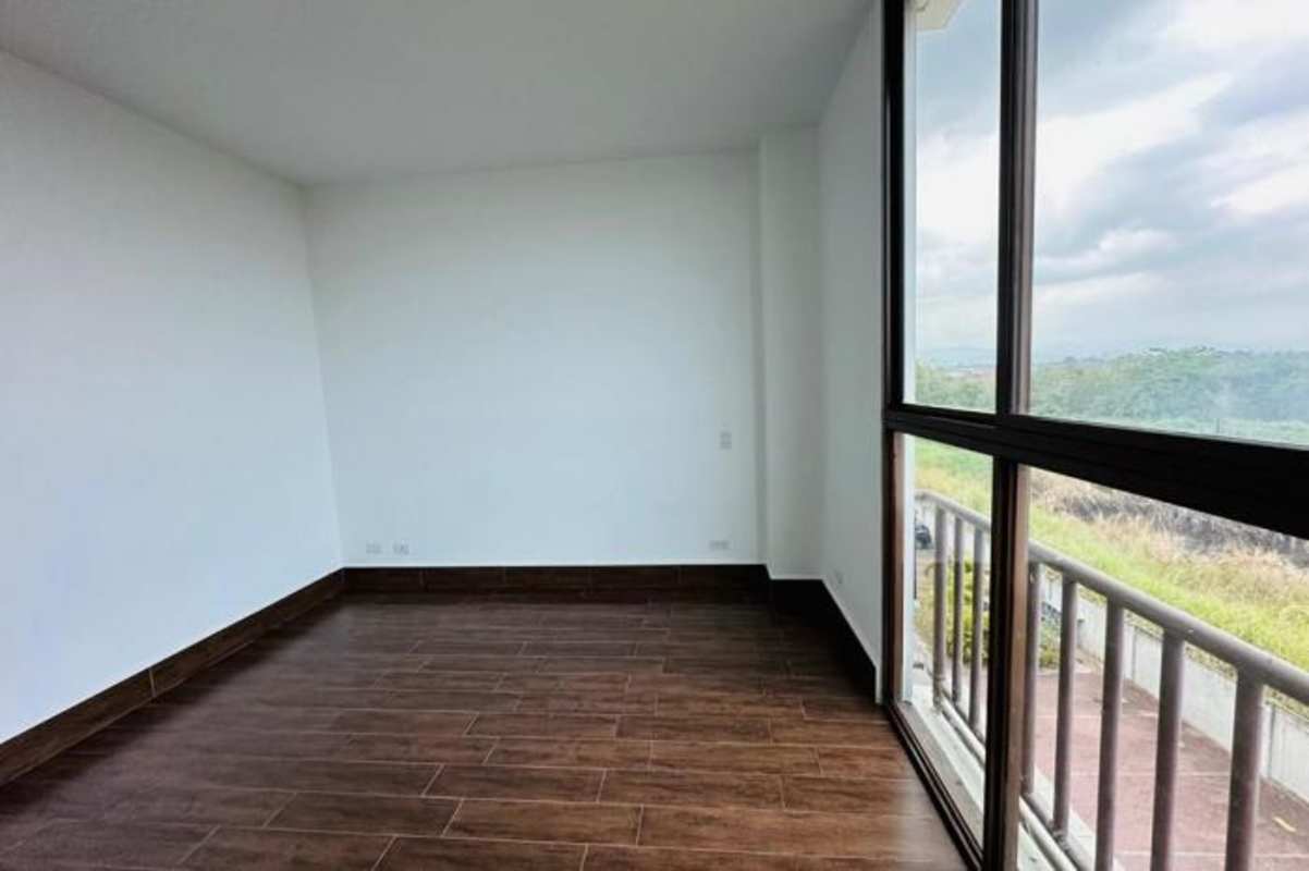 Covered balcony terrace with tiled floor and pillars overlooking gardens at PH Costamare Panama