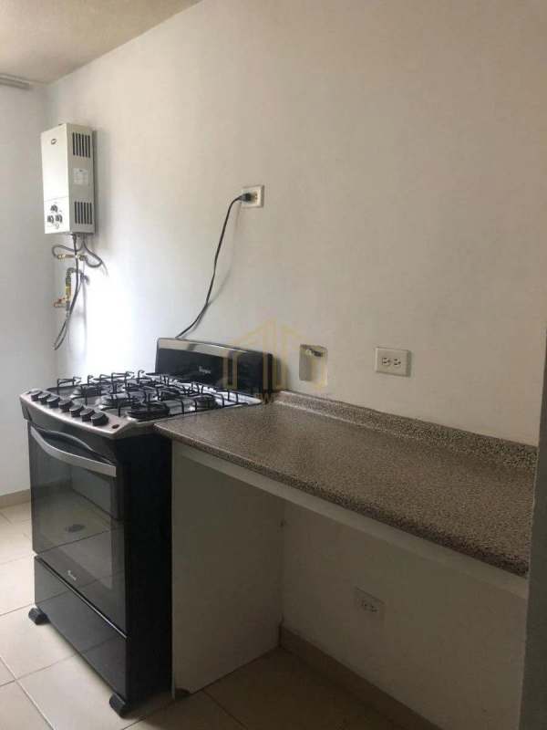 Functional granite countertop kitchen with refrigerator, gas stove, and white cabinets PH Residencial Llano Bonito Juan Díaz Panama