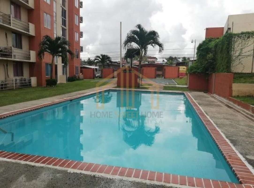 Outdoor children's play area with lawn next to apartment buildings PH Residencial Llano Bonito Panama City