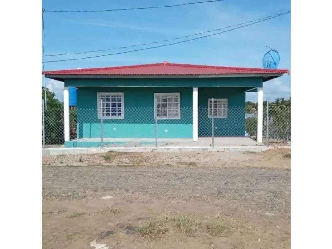 Fenced backyard elevated blue water tank banana trees Chepo house for sale Hola Realty