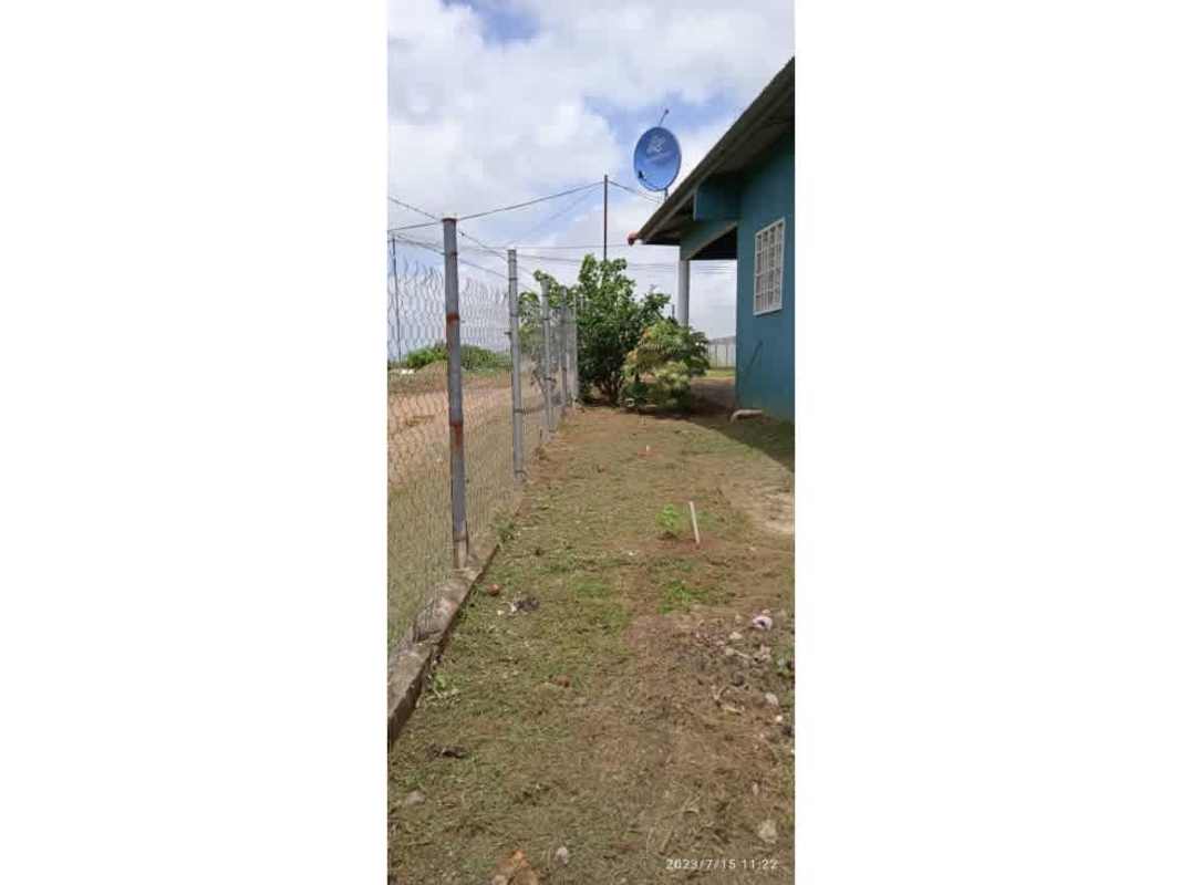 Side exterior with fence satellite dish blue house yard Chepo Panama affordable home