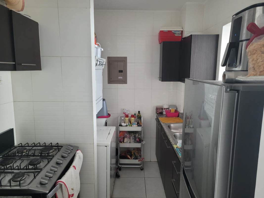 Modern compact kitchen with laundry appliances and granite counter at Vivendi 300 Panama City