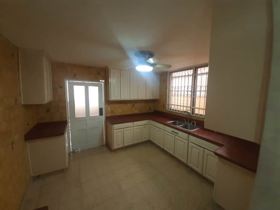 Kitchen with brown countertops, white cabinets, large window, L-shaped design in Betania Panama