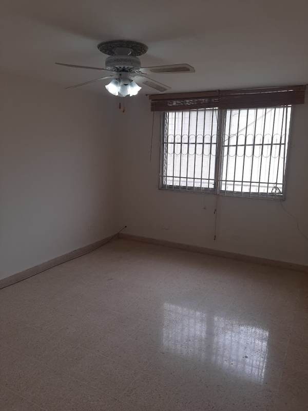 Empty bright room with ceiling fan, tile floors, and security bars in Los Angeles neighborhood Panama