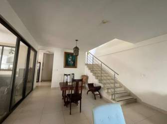 Spacious open dining area with glass railing staircase, wooden table River Valley house