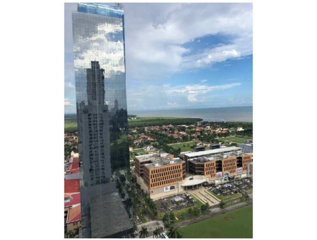 Aerial photo of Costa del Este skyline, business complex and Pacific Ocean coastline from above Time Square Center Panama