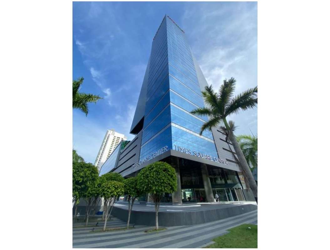 Modern commercial glass building with palm trees at Time Square Center in Costa del Este business district, Panama