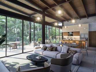 Spacious bedroom with large glass doors opening to terrace with ocean view at Sanctuary Gardens Pedasí Panama