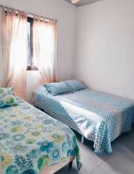 Small bedroom with double bed, ceiling fan, window in duplex near beach