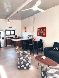 Modern open concept kitchen dining living room with large windows and stylish décor in duplex beach house