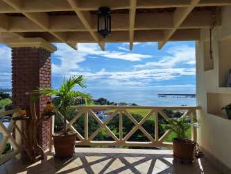 Bright living room with floor-to-ceiling windows and ocean view in penthouse PH Roca Marina, Vista Mar Resort Panama.