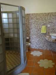 Modern bathroom with curved glass block shower and mosaic wall at Buenaventura villa Panama