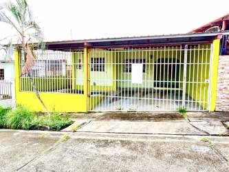 Yellow house facade with gated carport and security fence Brisas de Arraiján Panama Oeste