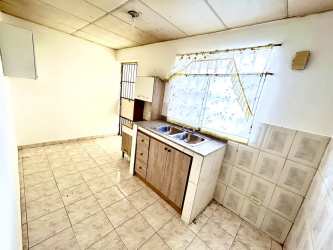 Simple minimalist kitchen with window and double sink at Brisas de Arraiján house Panama Oeste